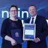 Dr Marek Kluszczyński z dyplomem laureata na scenie konferencji NIL IN Summit